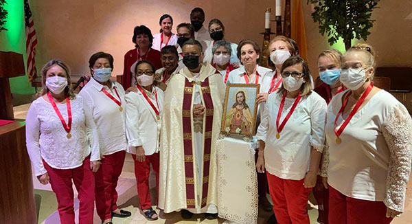 Father Gustavo Barros, parochial vicar at St. Louis Parish in Pinecrest, gathers with new members of the Guard of Honor at the church. Father Barros is the new spiritual director for the Guard of Honor Center, the first in Florida.