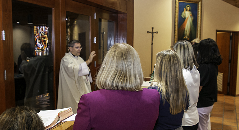 New principals receive a blessing from Msgr. Dariusz J. Zielonka of the Metropolitan Tribunal at the conclusion of Mass during their orientation day, July 29, 2021. The archdiocese's new superintendent of schools, Jim Rigg, welcomed a cohort of eight new principals and two second-year principals to the orientation session at the Pastoral Center. The new principals also spent some time with veteran principals who have been assigned to them as mentors.