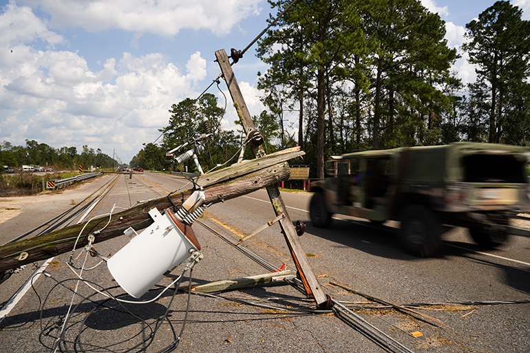 A vehicle passes downed power lines on Sept. 1, 2021 in Albany, Louisiana, one of the parts of Louisiana where Ida made landfall as a Category 4 hurricane Aug. 29, 2021, bringing flooding, wind damage and power outages along the Gulf Coast. (Photo by Sean Rayford/Getty Images)