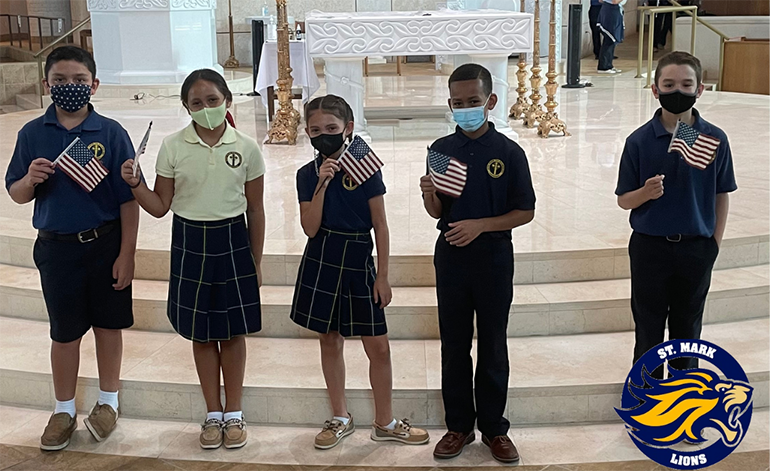 St. Mark students hold up flags to mark Patriots Day, this year leading up to the 20th anniversary of the Sept. 11 attacks. Students at the Southwest Ranches school wore red, white, and blue accessories with their uniforms Sept. 8, 2021.