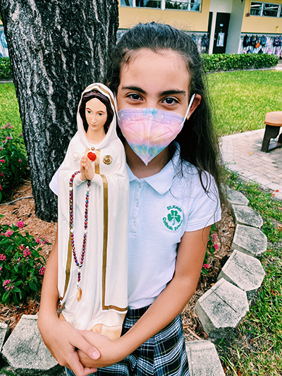 Vanessa Medina, a fifth grade student at St Kevin School, holds her statue of La Virgen Maria Rosa Mystica.