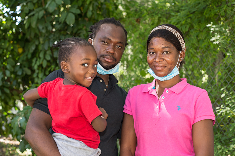 Kevin-Jay Metellus, de 28 meses, su padre, Kervens Metellus, y su madre, Marlene Belizaire posan para una foto en el patio de Notre Dame d'Haiti el 26 de septiembre de 2021, poco después de llegar de Del Rio, Texas.