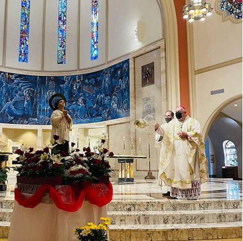 Archbishop Thomas Wenski blesses an image of San Lorenzo Ruiz, the first Filipino saint who was martyred in Japan in the 17th century, during a Mass with the Filipino community at St. Mary Cathedral, Sept. 26, 2021. The saint's feast day is Sept. 28.