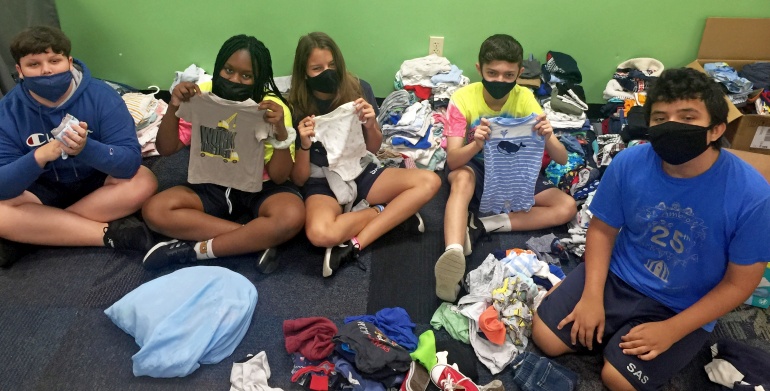 Students at St. Ambrose School show some of the supplies their fellow students collected for a local pregnancy center.