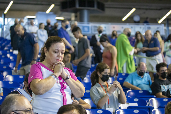 Luz Spinola prays after receiving Communion, during the first ever "Mass at the Park" celebrated at LoanDepot Park in Miami, Oct. 3, 2021.