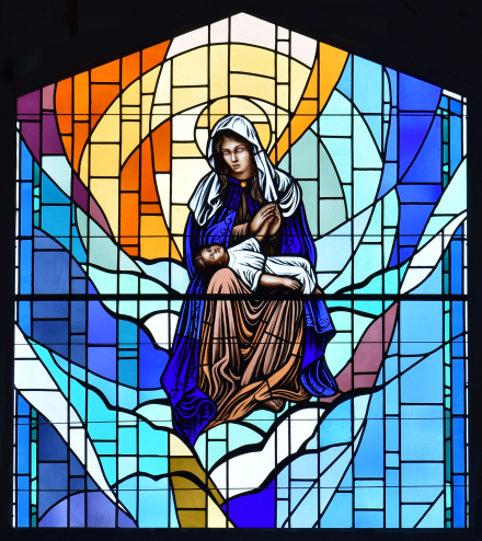 María acuna al Niño Jesús en este vitral situado en la capilla de adoración de la iglesia. Las imágenes de Nuestra Señora de la Divina Providencia pretenden mostrar su cuidado hacia Él.