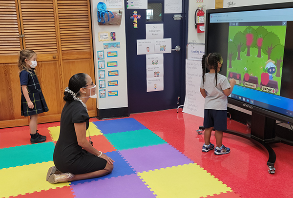 PreK3 students from St. Mark School show Principal Teresita Wardlow how they work and solve problems on a smart board in the classroom. St. Mark's has been named a 2021 Apple Distinguished School for their innovation, leadership and educational excellence.