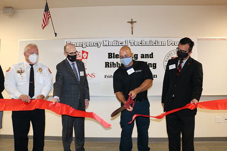 Omar Jirau, a 1995 graduate of Cardinal Gibbons High School and Emergency Medical Technician instructor for the school and Barry University in Miami Shores, cuts the ribbon during ceremonies Sept. 24, 2021 at the Fort Lauderdale school.