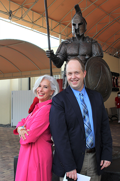 Msgr. Edward Pace High School alum and principal, Ana Garcia, and Archdiocese of Miami Superintendent of Schools Jim Rigg pose in front of the school's Spartan statue. The school is celebrating 60 years since its doors first opened in the Archdiocese of Miami.