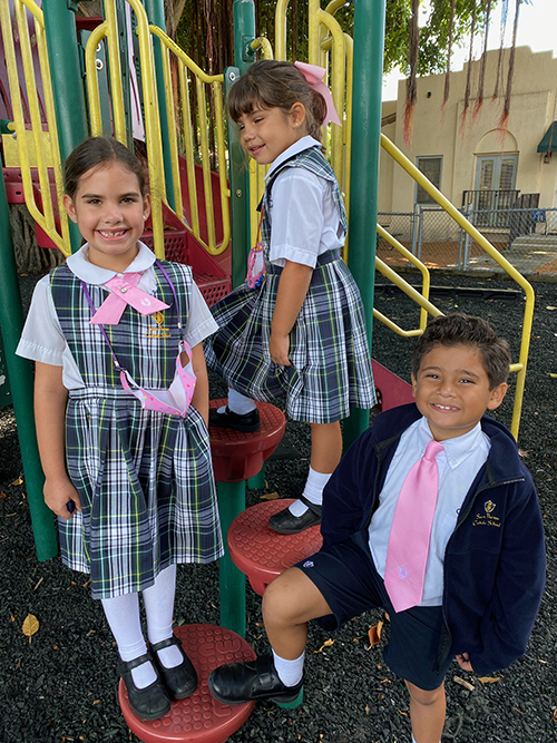 St. Theresa School second grader Annelise Cortinas, kindergartener Camila Vidal and second grader Jacob Cruz look pretty in pink for Breast Cancer Awareness Month.