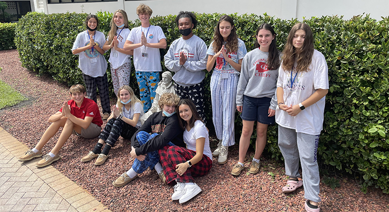 Sophomores in Nelson Araque's period C theology class pose around the statue of St. Francis of Assisi on the Cardinal Gibbons High School campus as part of their class study of the saint's legacy and how his teachings can impact today's world.