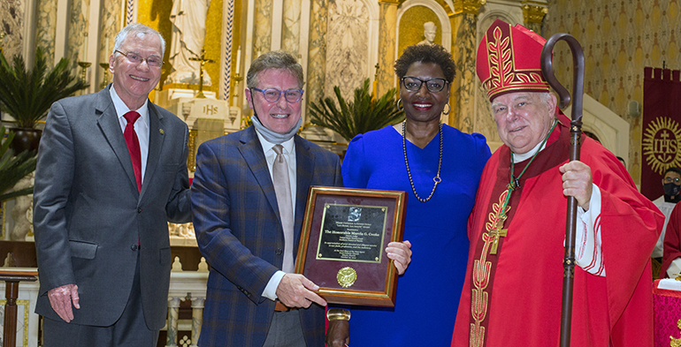 Posing for a photo during the Lex Christi, Lex Amoris award presentation, from left: Francis Sexton, Jr., president of the Miami Catholic Lawyers Guild; Randy McGrorty, CEO of Catholic Legal Services and last year's recipient; U.S. District Court Judge Marcia Cooke, this year's recipient; and Archbishop Thomas Wenski, who celebrated the annual Red Mass with the Miami Catholic Lawyers Guild Oct. 25, 2021 at Gesu Church in downtown Miami.