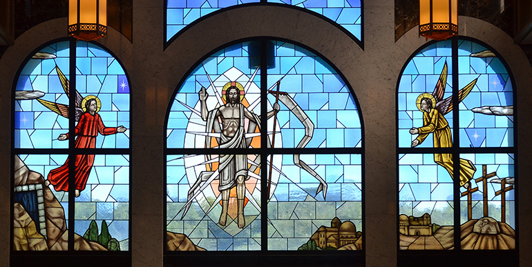 Jesus rises from the grave, flanked by angels, in this triple-wide window at Our Lady Queen of Peace Cemetery in North Lauderdale.