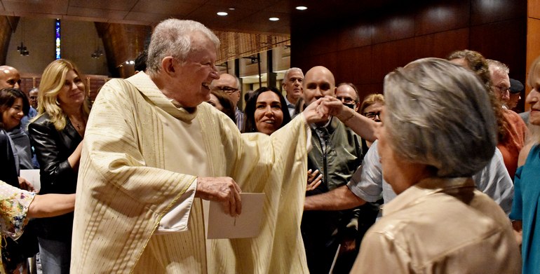 Msgr. Jude O'Doherty greets well-wishers after the 70th anniversary Mass at Epiphany Church, South Miami. Msgr. O'Doherty, a former pastor at the church, gave the homily.
