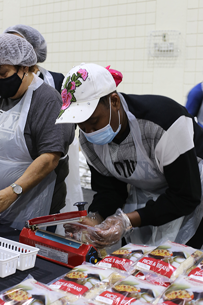 Berlande Richard, 19, a Barry University nursing student, seals a bag shut while assembling "40,000 Meals in 4 Hours," Nov. 8, 2021. The meals were to be distributed by Cross Catholic Outreach to the poor in Haiti and South Florida.