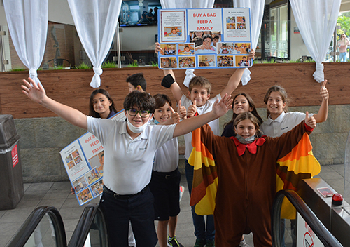 St. Agnes Academy fifth graders promote their school's Thanksgiving Food Drive outside the local Winn Dixie.