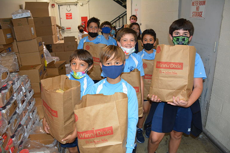 St. Agnes Academy fourth graders help pack Thanksgiving food bags for delivery to the Redlands Christian Migrant Association.