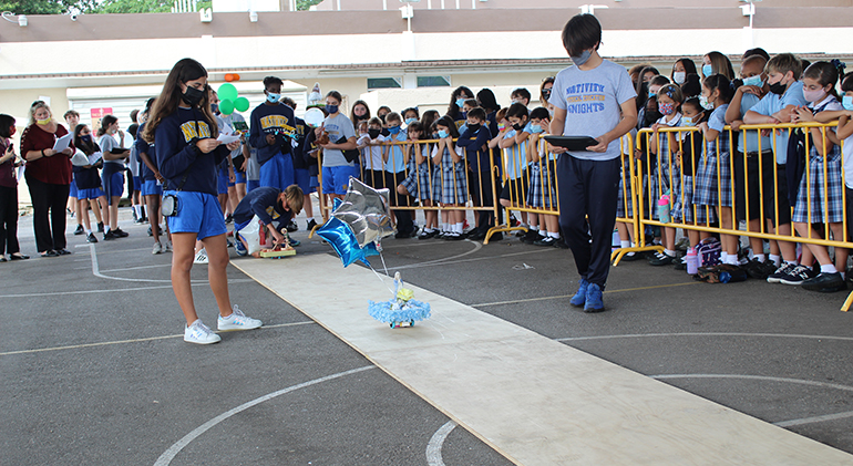 Nativity School eighth-graders guide their floats down the "parade" route while narrating their chosen saint's life to the younger students.