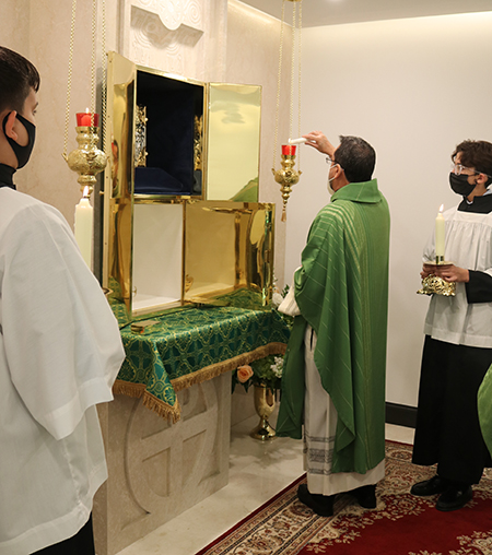 El P. Jorge Carvajal-Niño, administrador de la parroquia Mother of Christ, enciende las velas de la nueva capilla del Santísimo Sacramento de la parroquia que fue bendecida por el Arzobispo Thomas Wenski el 7 de noviembre de 2021.