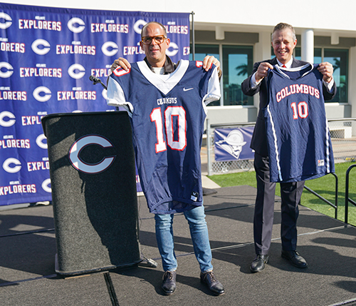 El exalumno Marcus Lemonis (izquierda) y el presidente de la secundaria Columbus, Thomas Kruczek, sostienen camisetas del equipo de la escuela con el número 10, en honor a la donación de 10 millones de dólares que Lemonis hizo a su Alma Mater y que se anunció el 9 de diciembre de 2021. La donación incluye una "propina" de 18,000 dólares para todos los profesores y trabajadores de la escuela dirigida por los Hermanos Maristas.