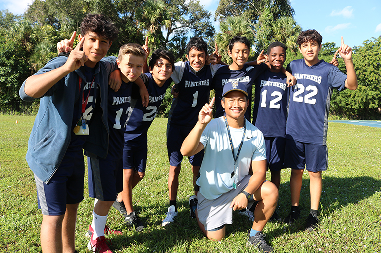 Coach Benjamin Savath, new physical education teacher, athletic director and soccer coach at St. Jerome School, poses with his undefeated soccer team.