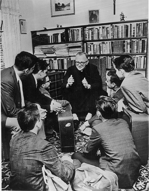 Iconic image of Msgr. Bryan Walsh speaking to some of the unaccompanied Cuban minors who came to Miami via the Pedro Pan program he directed. From 1960 to 1962, Pedro Pan brought more than 14,000 Cuban minors to the U.S. Msgr. Walsh arranged for Catholic Charities agencies throughout the U.S. to house and educate them until they could be reunited with their parents. The program has continued in the Archdiocese of Miami since then.