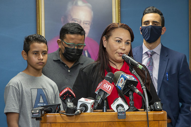 Catholic Legal Services' staff attorney Alberto Montequin, rear right, stands by as Yesenia, who lives in Miami, expresses her gratitude to Catholic Charities' Msgr. Bryan O. Walsh Children's Village where her son, Andy, rear left, spent 11 days before being reunited with her after crossing the border from Honduras. Also looking on is his stepfather, Manuel. Shelters throughout Florida such as the one run by Catholic Charities are in danger of being shut down by an executive order from Gov. Ron DeSantis.