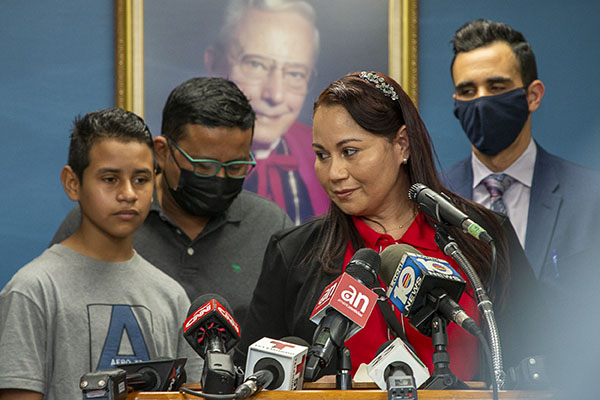 During a press conference Feb. 10, 2022, Catholic Legal Services' staff attorney Alberto Montequin, rear right, stands by as Yesenia, who lives in Miami, expresses her gratitude to Catholic Charities' Msgr. Bryan O. Walsh Children's Village where her son, Andy, rear left, spent 11 days before being reunited with her after crossing the border from Honduras. Also looking on is his stepfather, Manuel. Shelters throughout Florida such as the one run by Catholic Charities are in danger of being shut down by an executive order from Gov. Ron DeSantis.