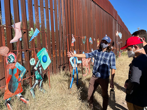 Estudiantes de Belén visitan un mural metálico pintado en el lado mexicano del muro fronterizo de Estados Unidos, en la ciudad de Heroica Nogales, Sonora, como parte de su viaje en noviembre de 2021 con la Iniciativa Fronteriza Kino.