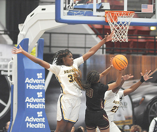 St. Thomas Aquinas' Alancia Ramsey (left) and Breanna Gustave (23) contest the shot of Wekiva's Jada Eads (10) during the second half of St. Thomas Aquinas' 59-45 victory over Apopka Wekiva in the FHSAA Class 6A girls basketball state-championship game, Feb. 26, 2022, at the RP Funding Center in Lakeland. Gustave and Eads led their teams with 23 points each, and Ramsey had 12 points.
