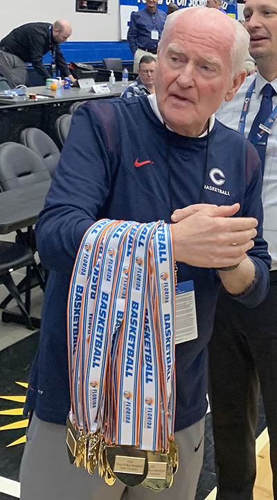 Athletic director Chris McKeon prepares to give medals to Columbus players and coaches after the Explorers' 45-44 victory over defending state champion Dr. Phillips, March 5, 2022 in the FHSAA Class 7A state boys basketball championship game at RP Funding Center in Lakeland. After Dr. Phillips won its first title last year, Columbus won its first title this year.