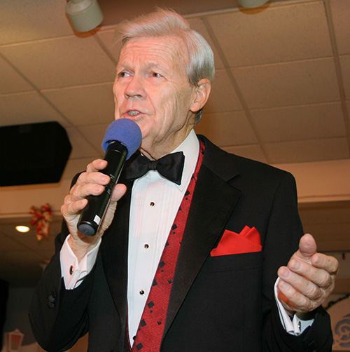 Msgr. James Reynolds, dressed in his tuxedo, sang and told jokes at Henry's Hideaway, the private club he founded as a "pastoral experiment" in building community at St. Henry Parish in Pompano Beach.
