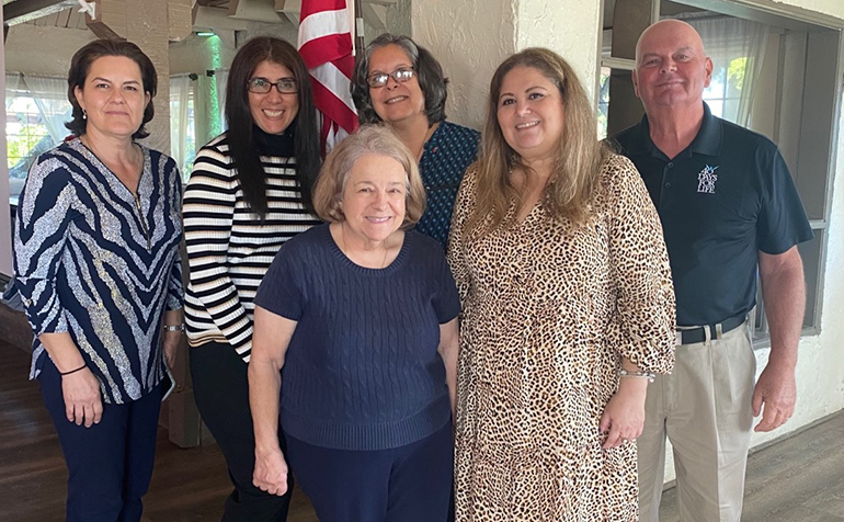 Los miembros del comité organizador de Miami-Dade Luncheons4Life, encabezados por Jacqueline Debs, al frente a la derecha, posan para una foto con Tom Walker, organizador de Luncheons4Life para el condado de Broward, después de un almuerzo en el 94th Aero Squadron en Miami en diciembre de 2021. De izquierda a derecha: María Villareal, defensora de los clientes de Respect Life North Dade; Raiza Rodríguez, presidenta de la junta directiva de Heartbeat of Miami; María Wadsworth (primera fila), organizadora de 40 Días por la Vida; y Madelyn Ocasio, representante de Respeto a la Vida en la parroquia St. Raymond y defensora de la vida en las aceras.