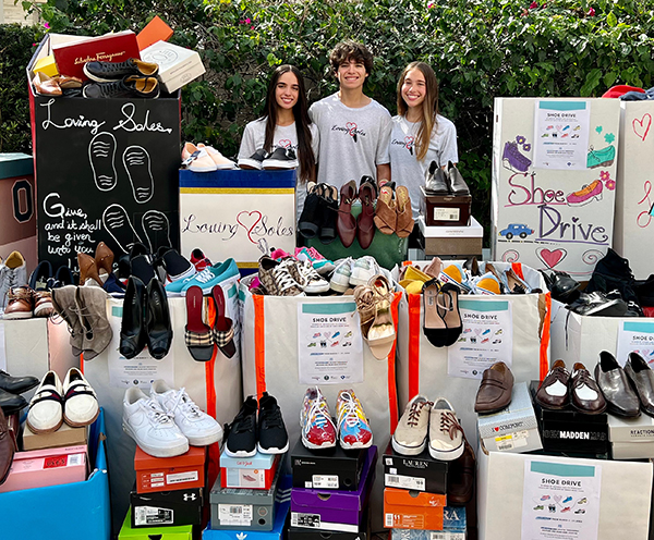 The Inguanzo siblings pause outside their home in Miami Lakes, headquarters of the Loving Soles collection drive for shoes for the homeless. From left are Sophia, Christopher and Sophia's twin, Susanna.