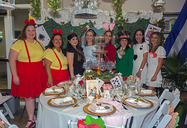 The "Alice in Wonderland" group pose for a photo in front of their table at the Literary Affair luncheon at St. Louis Covenant School, March 12, 2022.