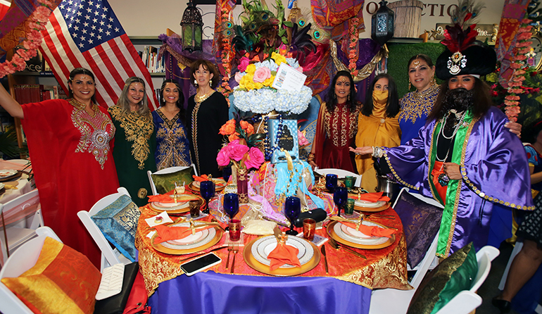 "The Arabian Nights" group pose for a photo in front of their table at the Literary Affair luncheon at St. Louis Covenant School, March 12, 2022.