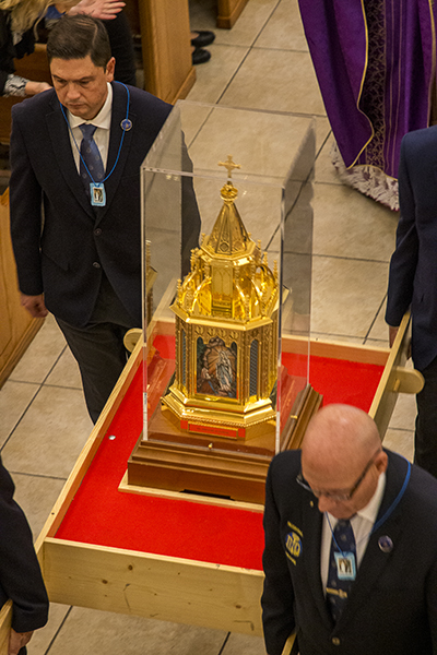 The reliquary of St. Bernadette is carried out of Our Lady of Lourdes Church for the outdoor candlelight procession.