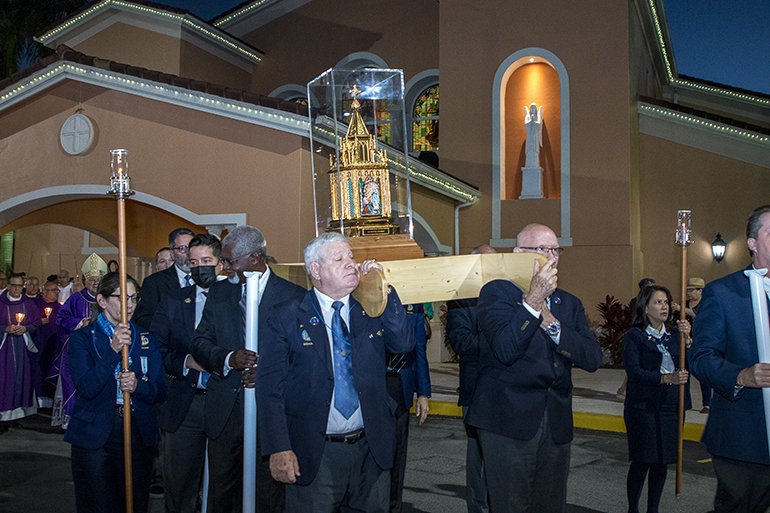 The reliquary of St. Bernadette is carried out of Our Lady of Lourdes Church for the outdoor candlelight procession, April 11, 2022.