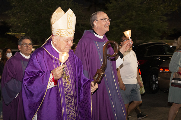 Archbishop Thomas Wenski and Msgr. Kenneth Schwanger lead the priests and faithful during the candlelight procession with the relics of St. Bernadette, April 11, 2022, at Our Lady of Lourdes Church in Miami.