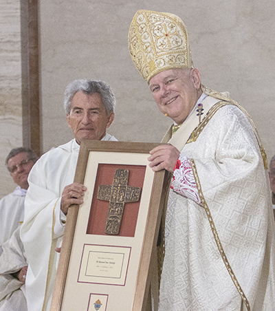 Father Sean Mulcahy receives a plaque from Archbishop Thomas Wenski commemorating his 60 years of priesthood, April 12, 2022.