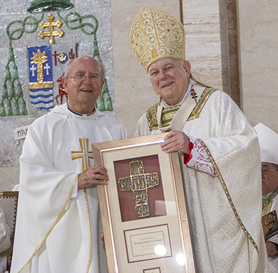 Msgr. Jose Luis Hernando receives a plaque from Archbishop Thomas Wenski commemorating his 60 years of priesthood, April 12, 2022.