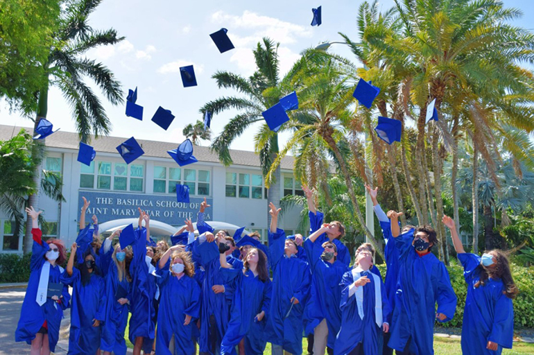 Graduates of The Basilica School of St. Mary Star of the Sea in Key West throw their caps in the air after graduating in 2022. The school is planning to expand to high school in the academic year 2023-24.