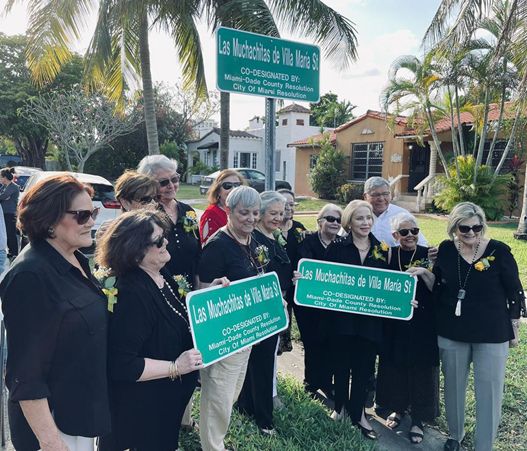 Algunas integrantes del grupo de Las Muchachitas de Villa María posan con los letreros donde se muestra la designación de una calle de la ciudad con el nombre de su grupo, el 12 de abril de 2022. Se les unió el comisionado de la ciudad de Miami, Manolo Reyes y otros invitados a la ceremonia.