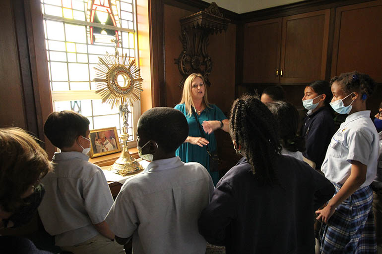 During a tour of St. Mary Cathedral, St. Mary Cathedral School Principal Julie Perdomo and fifth graders from St. Louis Covenant School and St. Mary Cathedral School stop by Archbishop John Favalora's vesting room, where a monstrance is kept.