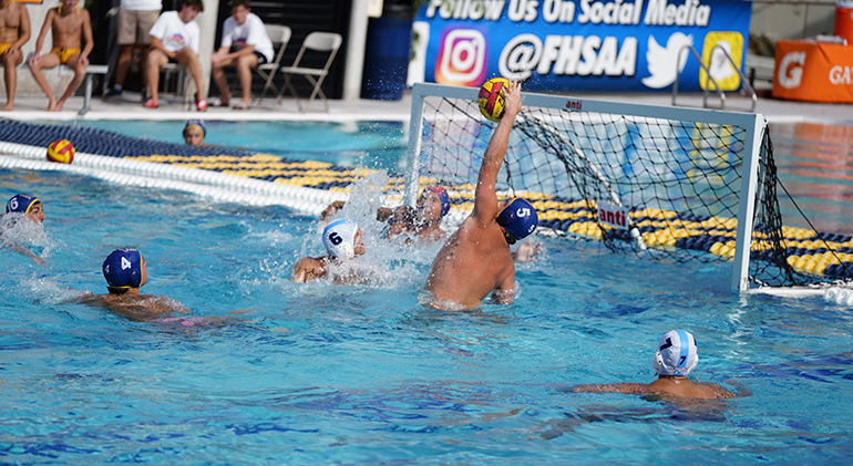 Senior Dylan Veccio (5) blocks a shot during Belen Jesuit Prep's championship water polo match April 23, 2022 in Miami. The Wolverines defeated Orlando's Dr. Phillips High School 17-13 to win the FHSAA state championship and complete an undefeated season.