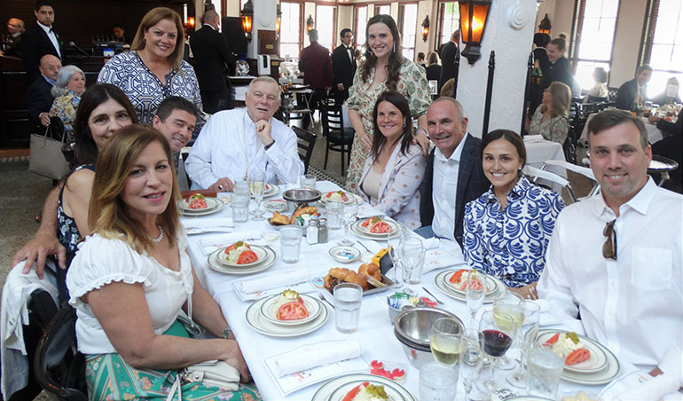 Archbishop Thomas Wenski joins guests at the table of "Presenting Sponsor" Jorge Luis and Isabel Rico, seated at rear right, at Cheers to Charity, the annual gathering at Joe's Stone Crab on Miami Beach to raise funds for archdiocesan charities. The event marked its 10th anniversary April 27, 2022.