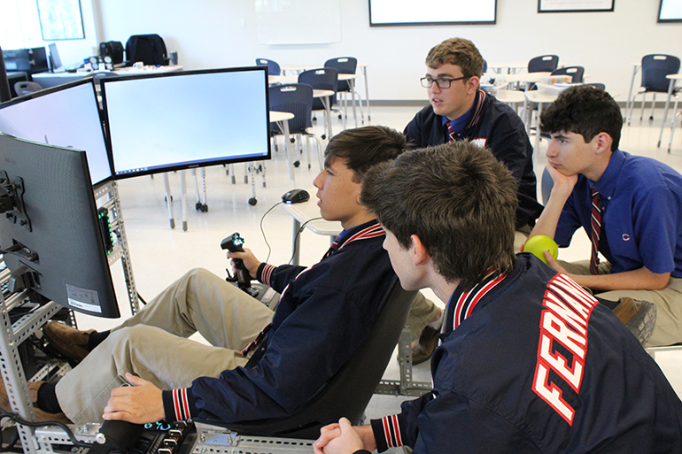 Christopher Columbus High students use a flight simulator in the Robert Sanchez Family Robotics and Engineering Lab/Muñoz Family Innovation Hub found in the new Marcus Lemonis and Mario Sueiras Center for Science and the Arts building at Christopher Columbus High, which was blessed and inaugurated on April 28, 2022.