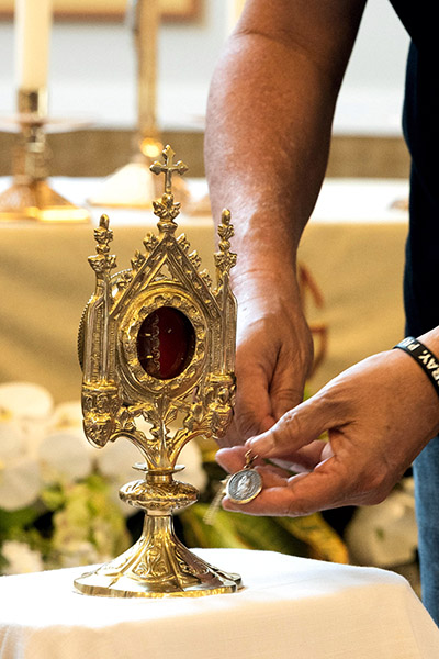 At St. Katharine Drexel Parish in Weston, a man places a religious medal near a relic of José Gregorio Hernández, a Venezuelan medical “doctor of the poor” whom Pope Francis beatified last year. After studying in Europe, Hernandez practiced medicine and would often visit sick patients without asking for payment for his services.
