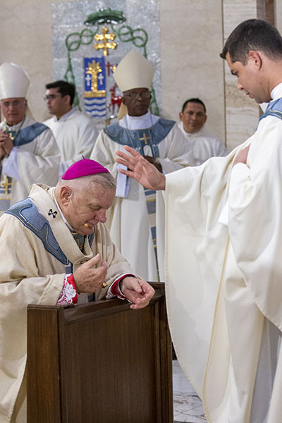 Archbishop Thomas Wenski gets a blessing from newly ordained Father Enzo Prendes at the conclusion of the ordination Mass, May 7, 2022 at St. Mary Cathedral.