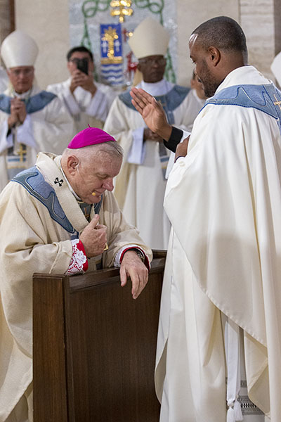 Archbishop Thomas Wenski gets a blessing from newly ordained Father Cesar Betancourt at the conclusion of the ordination Mass, May 7, 2022 at St. Mary Cathedral.